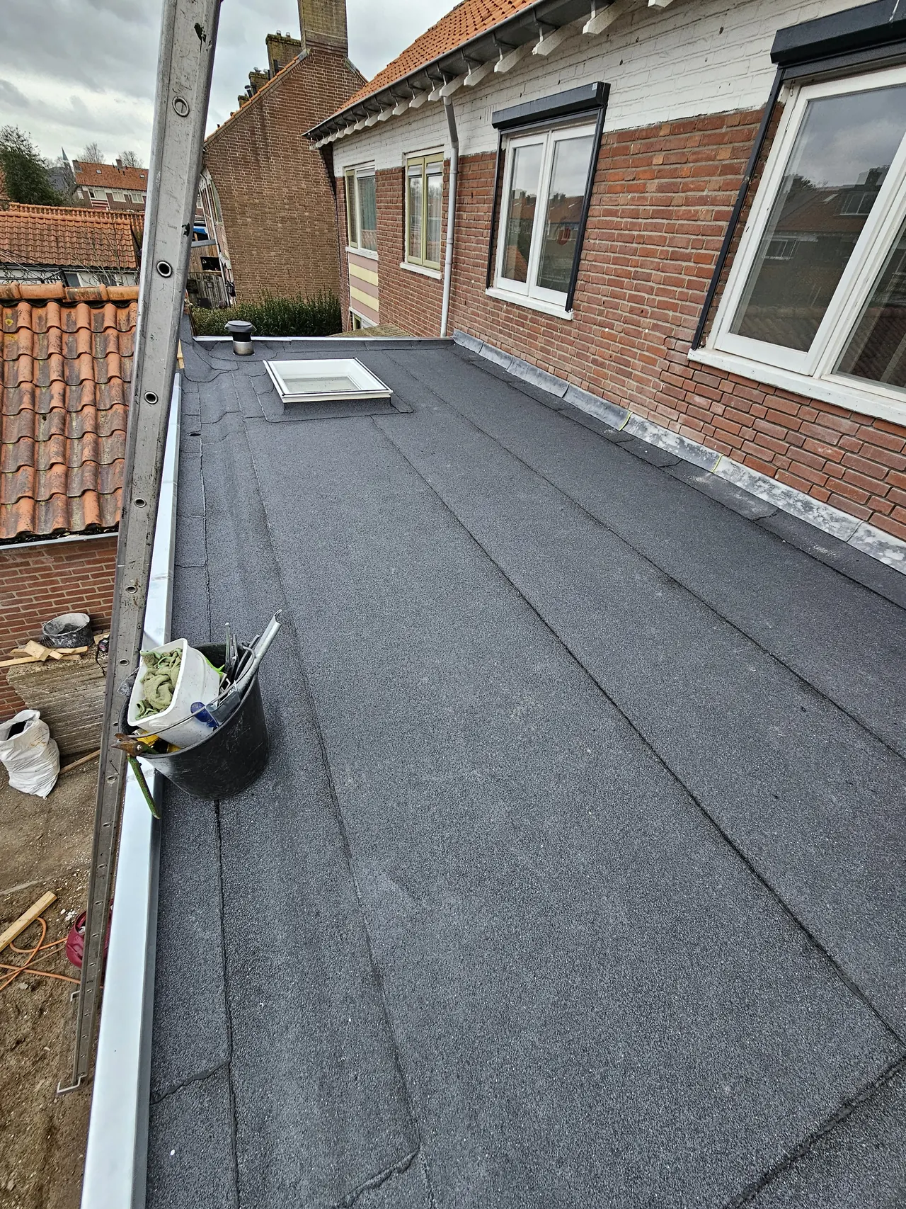 Bitumen dakbedekking rond een lichtkoepel op een uitbouw in Putten