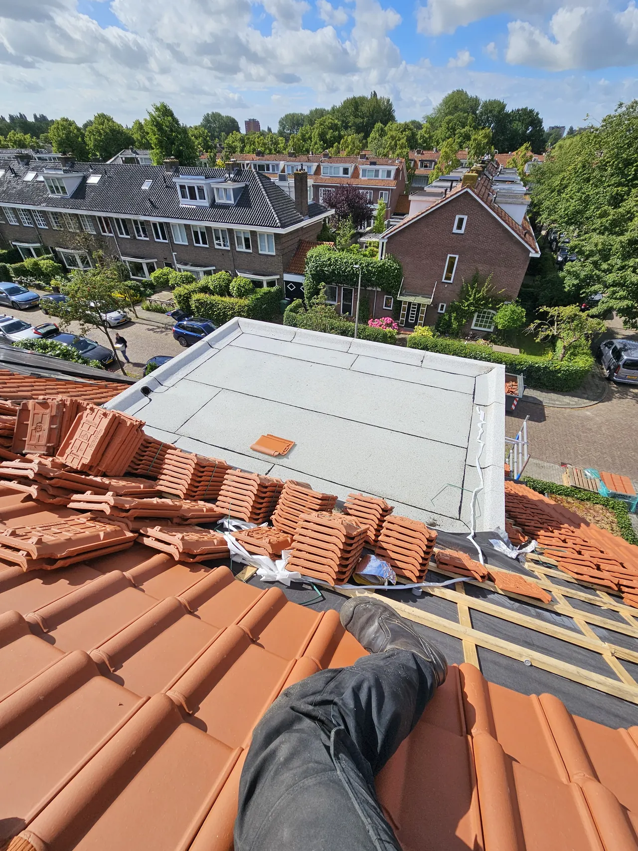 Wit bitumen op een dakkapel tussen dakpannen tijdens werkzaamheden in Soest