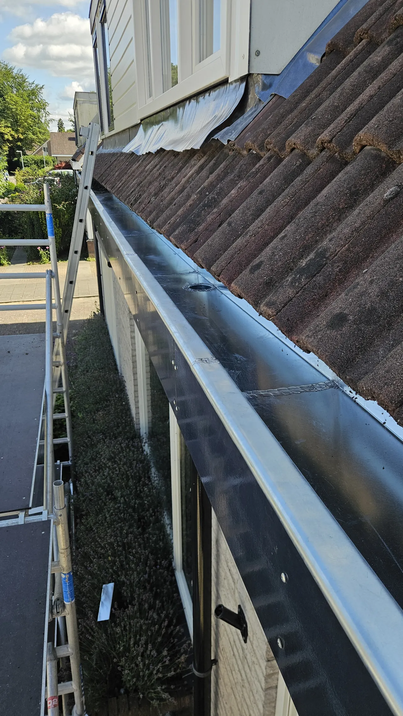 Metalen bakgoot onder een pannendak bij een renovatieproject in Ermelo