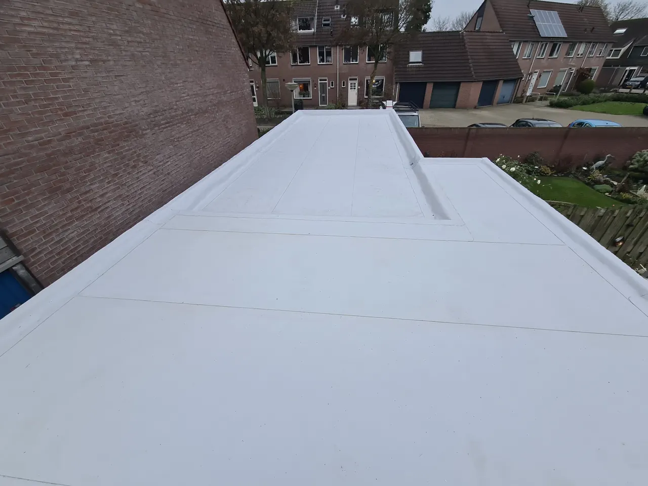 Lichtgekleurd Alkorplan PVC op een schuurdak langs een gevel in Ermelo
