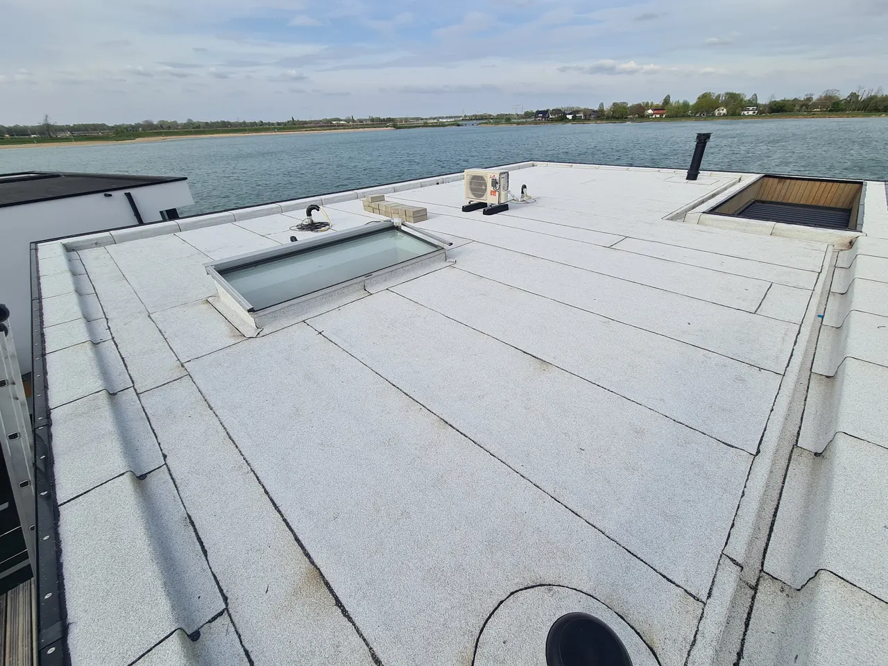 Wit bitumen op een plat woningdak met lichtopeningen in Nijmegen