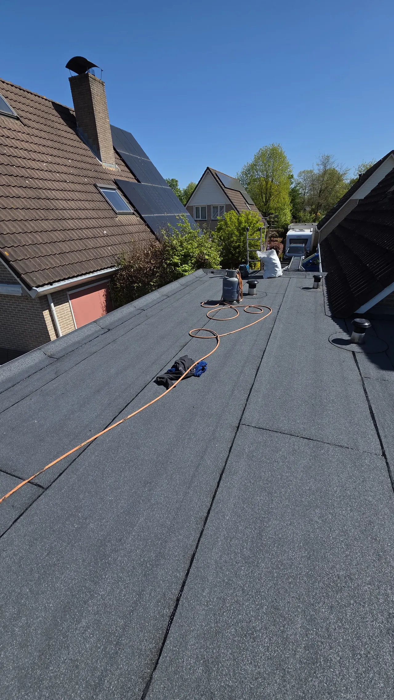 Bitumen dakbedekking op uitbouw en garage tijdens werkzaamheden in Putten