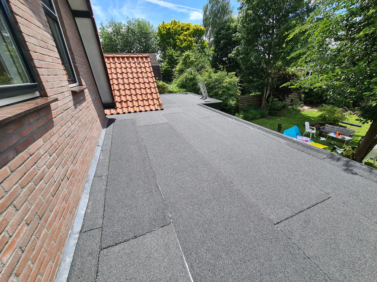 Nieuwe bitumen banen op het dak van een overkapping in Apeldoorn