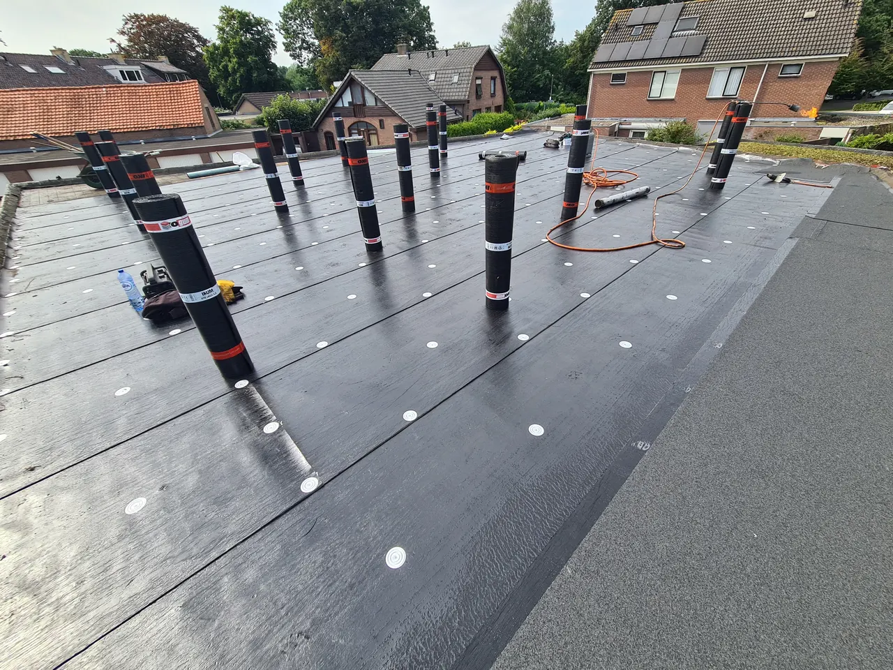 Dakrollen en onderlaag tijdens renovatie van een opslagdak in Harderwijk