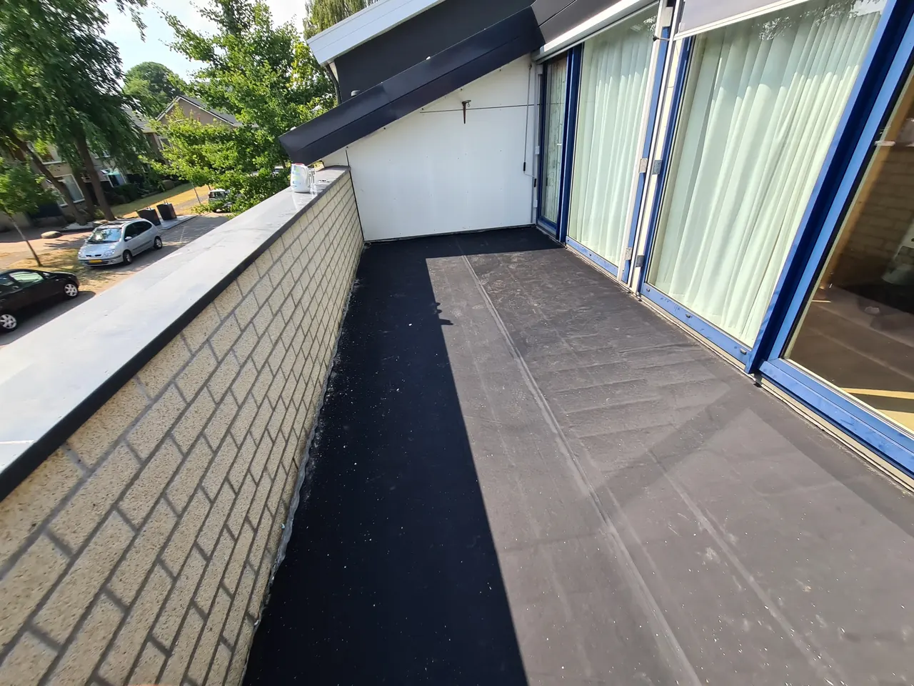 Hertalan EPDM op een balkondak tussen gevel en borstwering in Apeldoorn