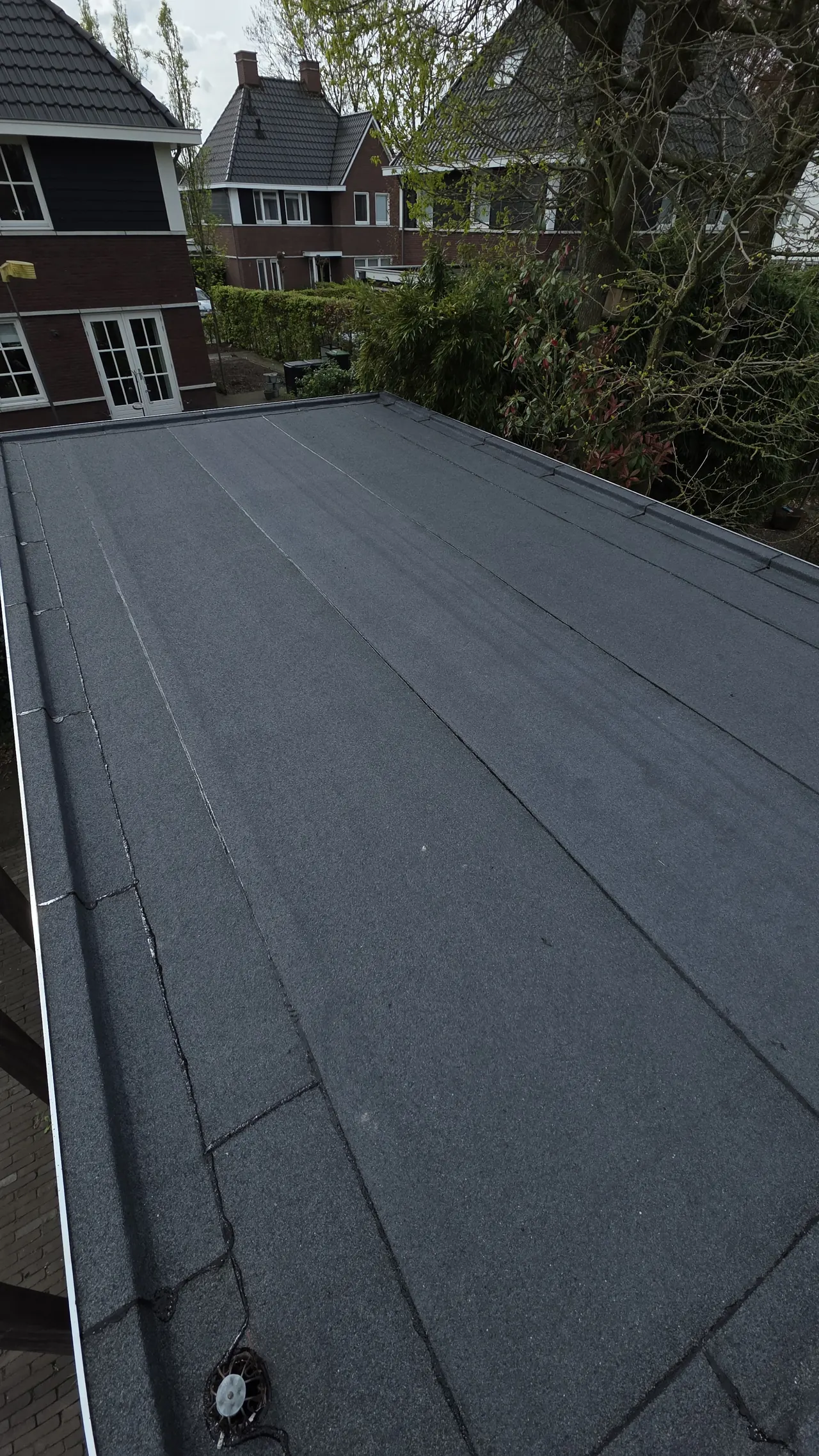 Gerenoveerd bitumen garagedak met zichtbaar afvoerpunt in Amersfoort